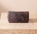Brown hand-tooled leather billfold purse with deep floral carving