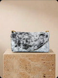 Black and white cowhide cell phone wallet purse with gold hardware and shoulder strap