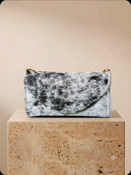 Black and white cowhide cell phone wallet purse with gold hardware and shoulder strap