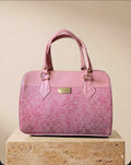 Pink hand-tooled leather barrel handbag with floral scroll detailing and gold hardware